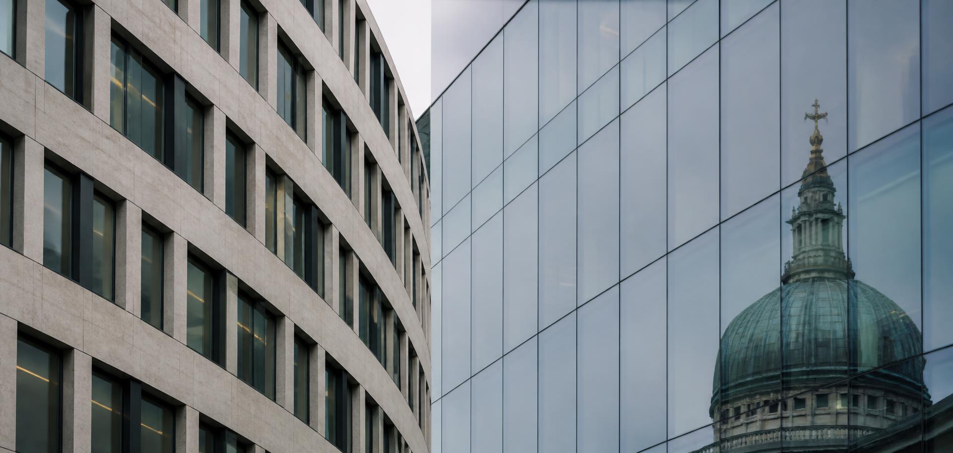 Modern London office facade reflecting the dome of St Paul's Cathedral